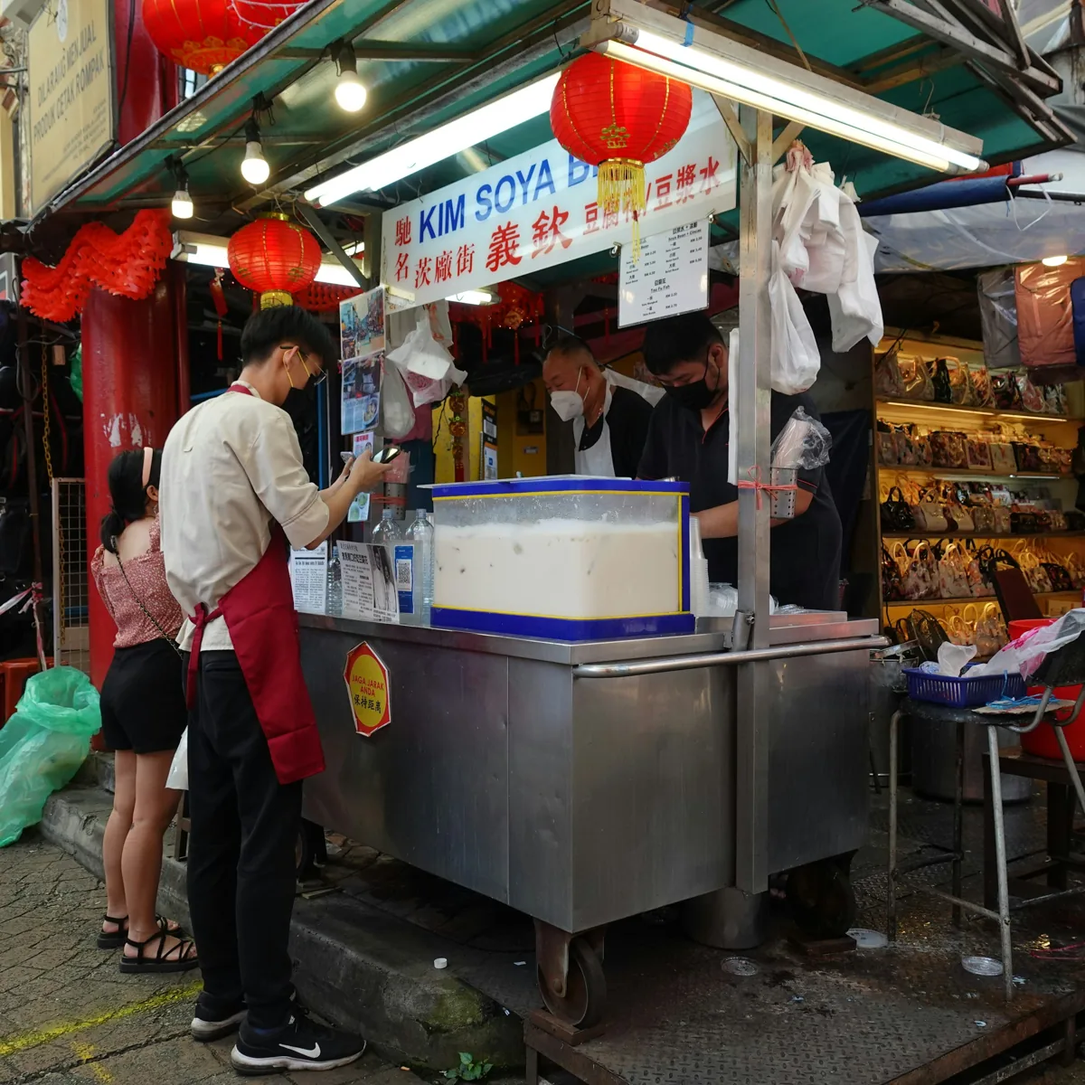 A customer at a soya bean drinks stall on Petaling Street, Kuala Lumpur